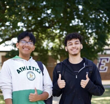 Two students are giving thumbs up.
