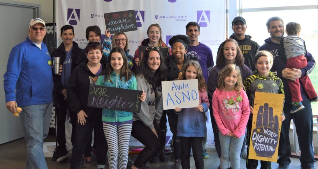 Small group of Nursing students, faculty and family posing before Dear Neighbor Day