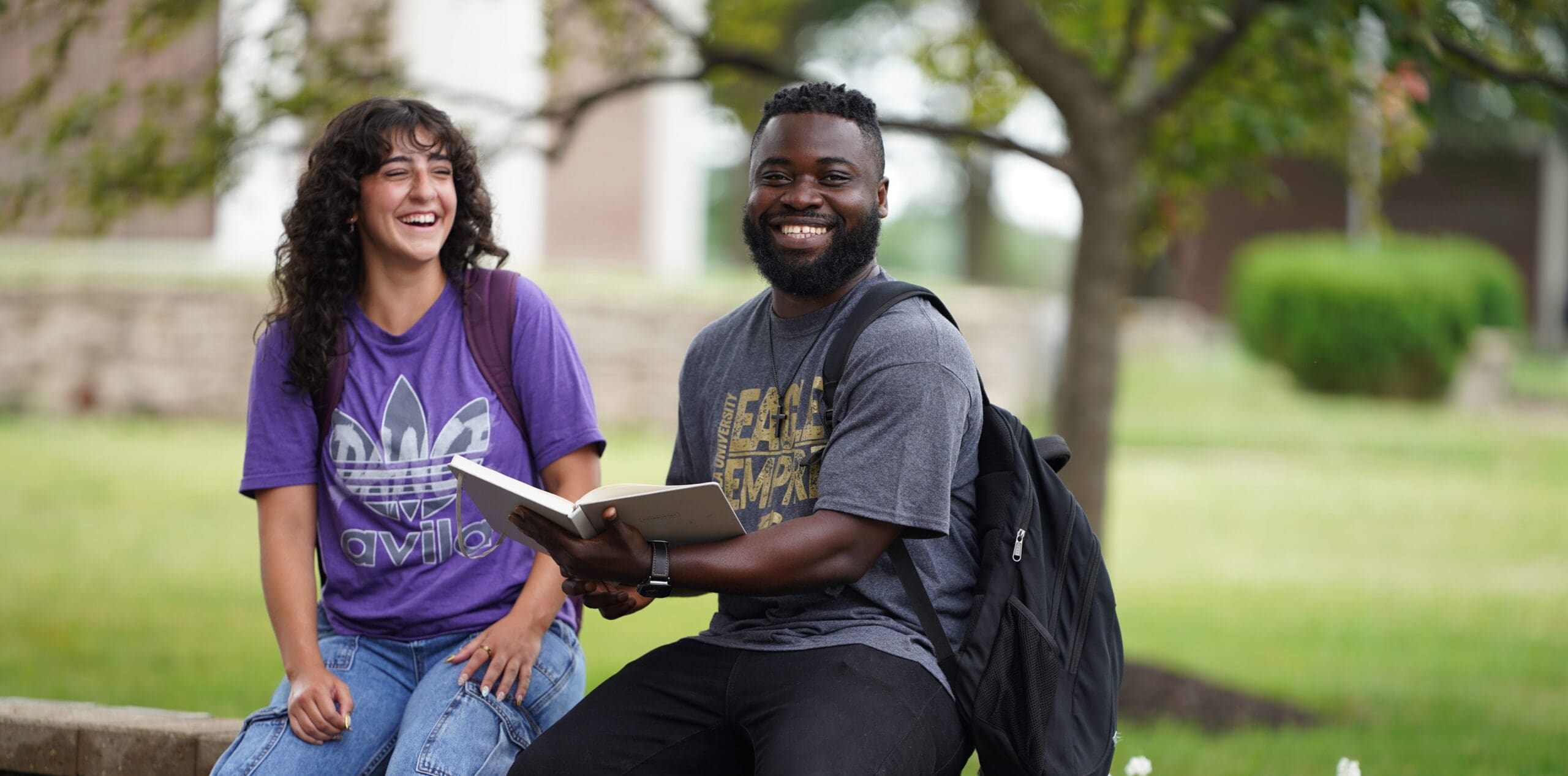 Two students conversing while seated on the bench