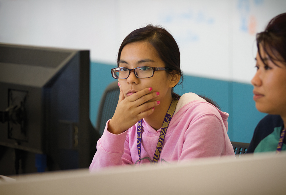 Two students intently studying a computer screen