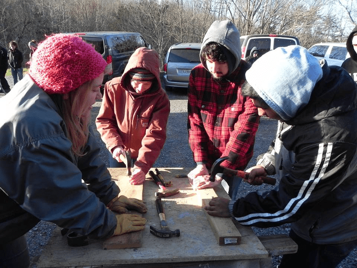 Four students using construction tools
